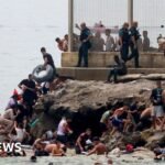 Hundreds of migrants swim from Morocco to Spanish enclave of Ceuta