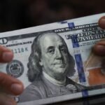 Dollar ticks up on Iran tensions, with US data in focus