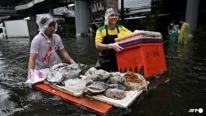 In kayaks or waist-deep in floodwater, shoppers return to Bangkok markets