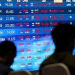 Stocks edge lower as dollar heads for weekly loss