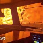 Dramatic video shows wildfire surround freight train in Canada