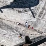 Watch: Helicopter hovers feet from cliff face during rescue